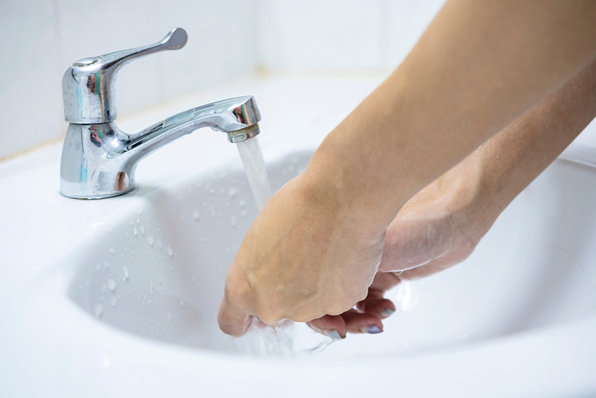 Woman washing hands in sink Woman washing hands in sink